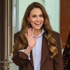 Princess Kate wearing a brown blazer and smiling