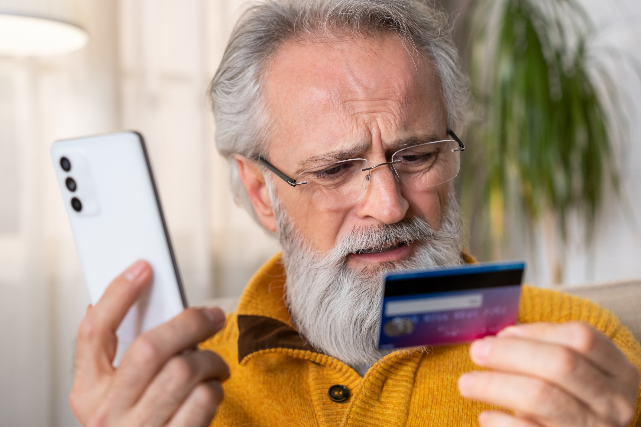 A man waiting on hold is frustrated with his credit card. 