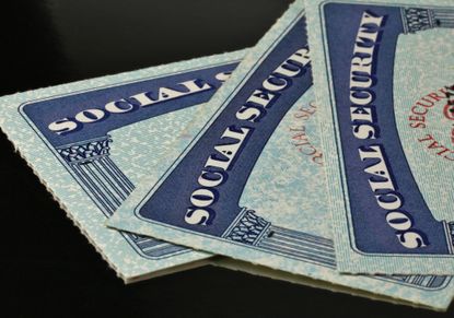 Three Social Security cards stacked on top of each other.