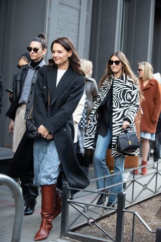 Karie Holmes wearing a coat, t-shirt, jeans, and boots