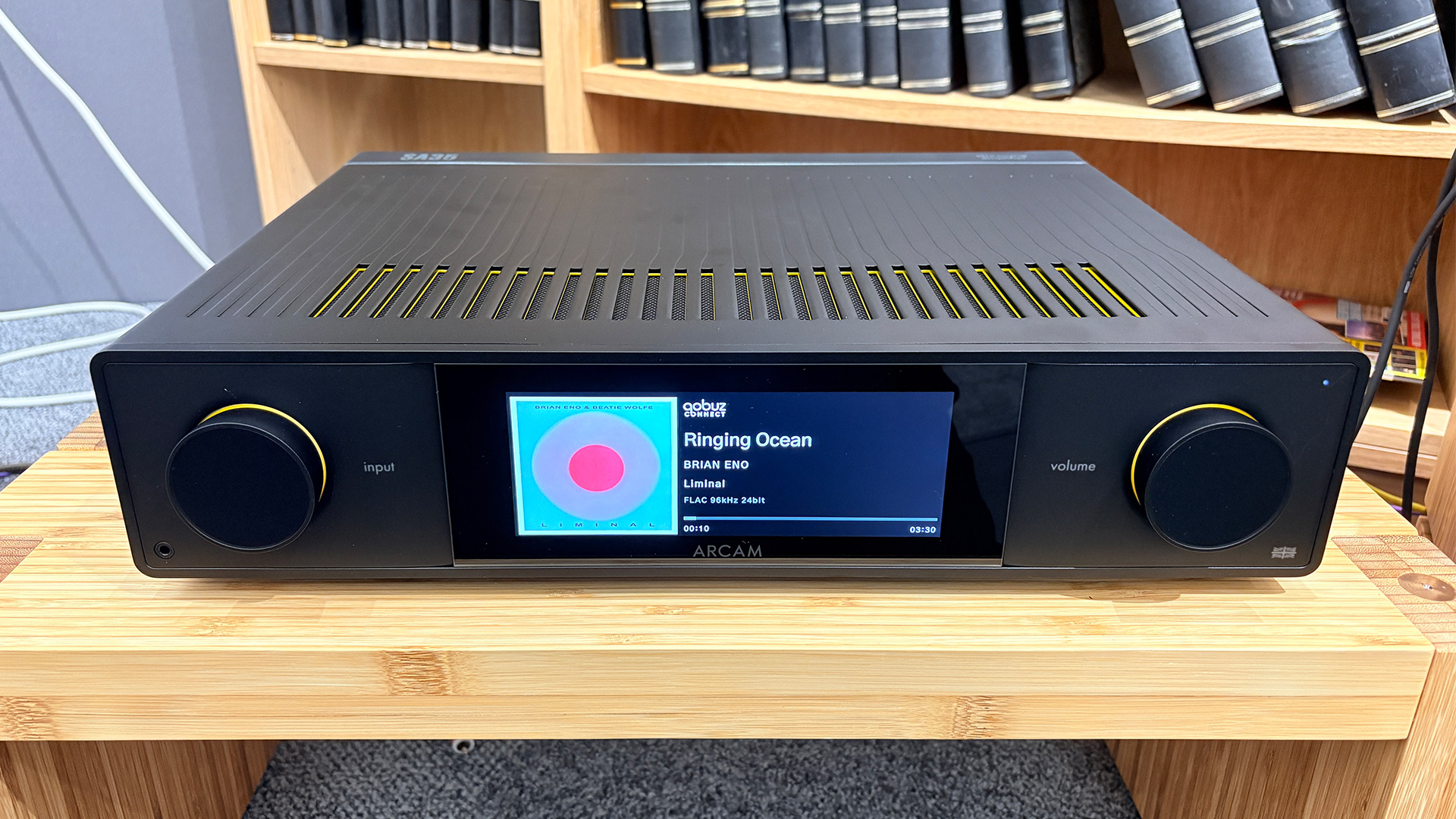 Arcam SA35 music streamer on wooden hi-fi rack in front of bookcase