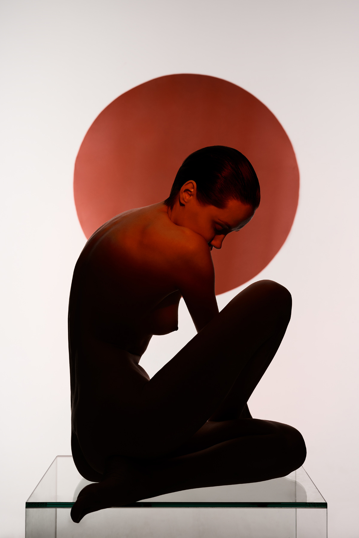 Woman standing in shadow in front of red and black circles