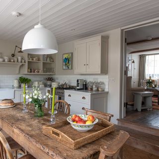 kitchen diner in a coastal cottage with rustic wooden table and chairs neutral colour scheme