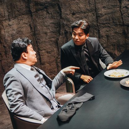 Judges Paik Jong-won and Anh Sung-jae discuss two dishes in a cave-like chamber, in 'Culinary Class Wars.'