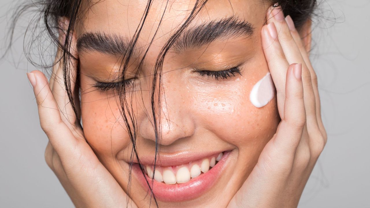 Woman smiling with face cream on her cheeks