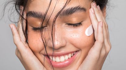 Woman smiling with face cream on