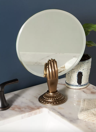 Brass hand motif vanity mirror from Anthropologie.