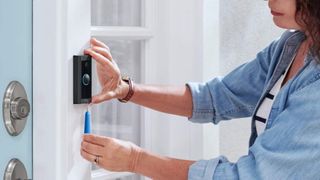 Ring Video Doorbell Wired being installed by woman in blue shirt