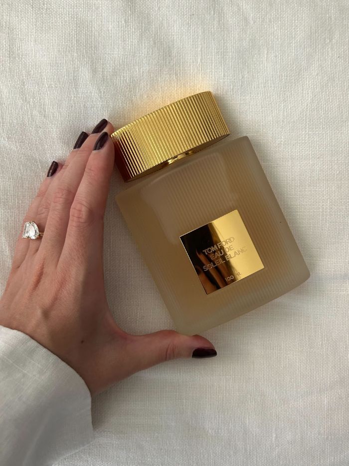 Młodsza redaktorka ds. urody Grace Lindsay trzyma perfumy Tom Ford Eau de Soleil Blanc