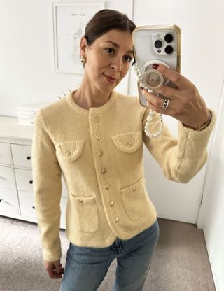 Woman in pale yellow sweater jacket.