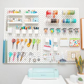 A pegboard with colorful craft supplies on it