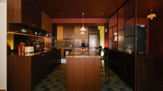 a deep red compact kitchen with butter yellow accents and timber cabinetry