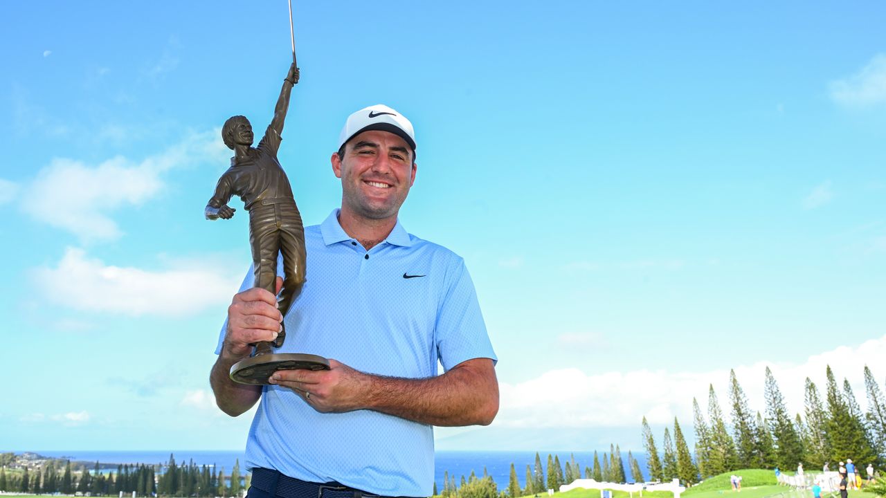 Scottie Scheffler holds the PGA Tour Player of the Year trophy