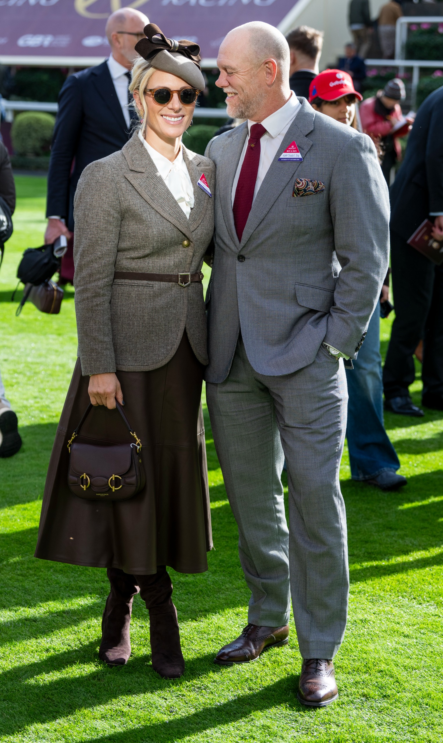 Zara Tindall posing in a leather skirt and blazer with Mike Tindall at Ascot Racecourse