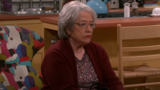 Kathy Bates sitting with an upset look in The Big Bang Theory.