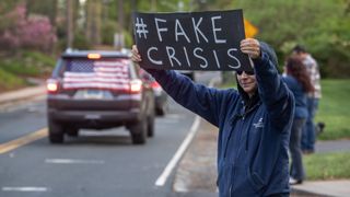 Protestors holding up signs. Demonstrators hold a "Rolling Car Rally" in front of Democratic Governor Ned Lamont's residence while protesting the state's stay-at-home order to combat the coronavirus (COVID-19) pandemic on May 04, 2020 in Hartford, Connecticut. 