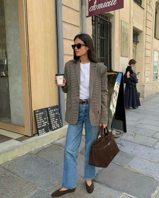 Frau trägt Jeans, Blazer, braune Tasche und Ballettschuhe