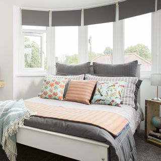 bedroom with white wall and glass window with grey blinds