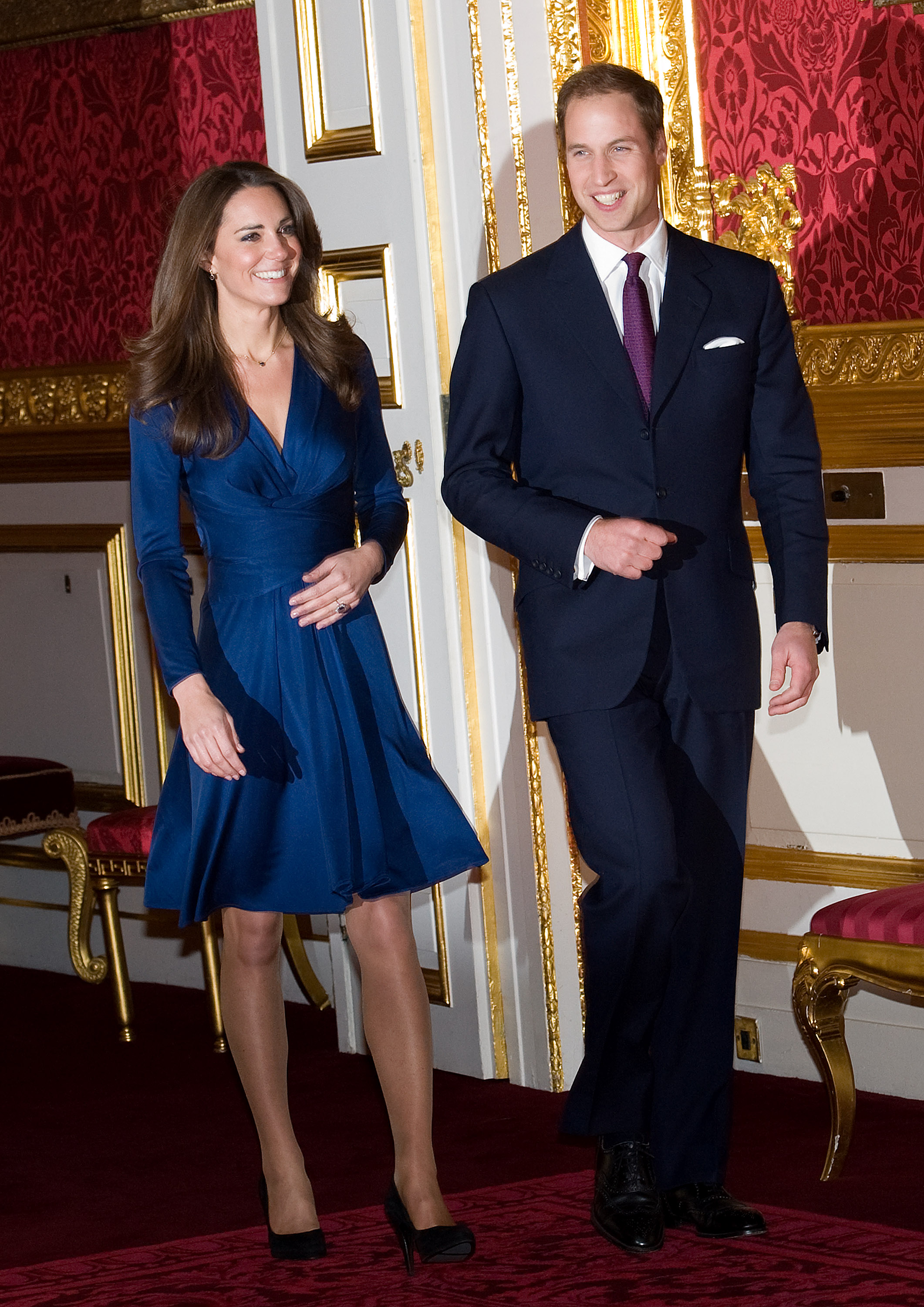 Kate Middleton wearing a blue wrap dress and Prince William wearing a suit at their engagement announcement