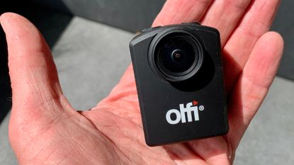 Olfi one.five Black action camera on someone's palm