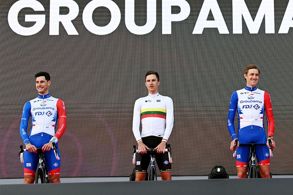 On the left, Jacopo Guarnieri (Groupama-FDJ) wears a a wristband of the light blue, pink and white colours of the transgender flag at the pre-race presentation of the Giro d&#039;Italia 