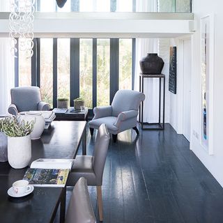 dinning area with white wall window and black flooring