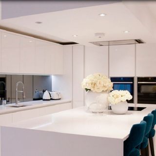 kitchen room with white kitchen cabinets and flower in white vase