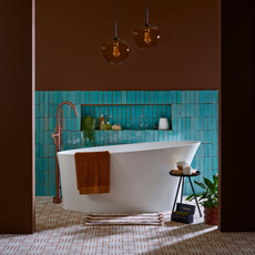 A brown and turquoise bathroom with patterned floor tiles and brown glass pendant lights