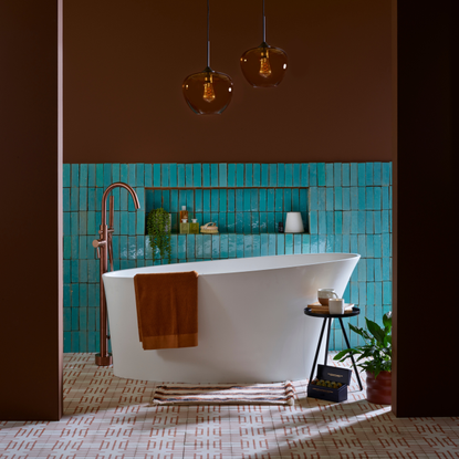 A brown and turquoise bathroom with patterned floor tiles and brown glass pendant lights