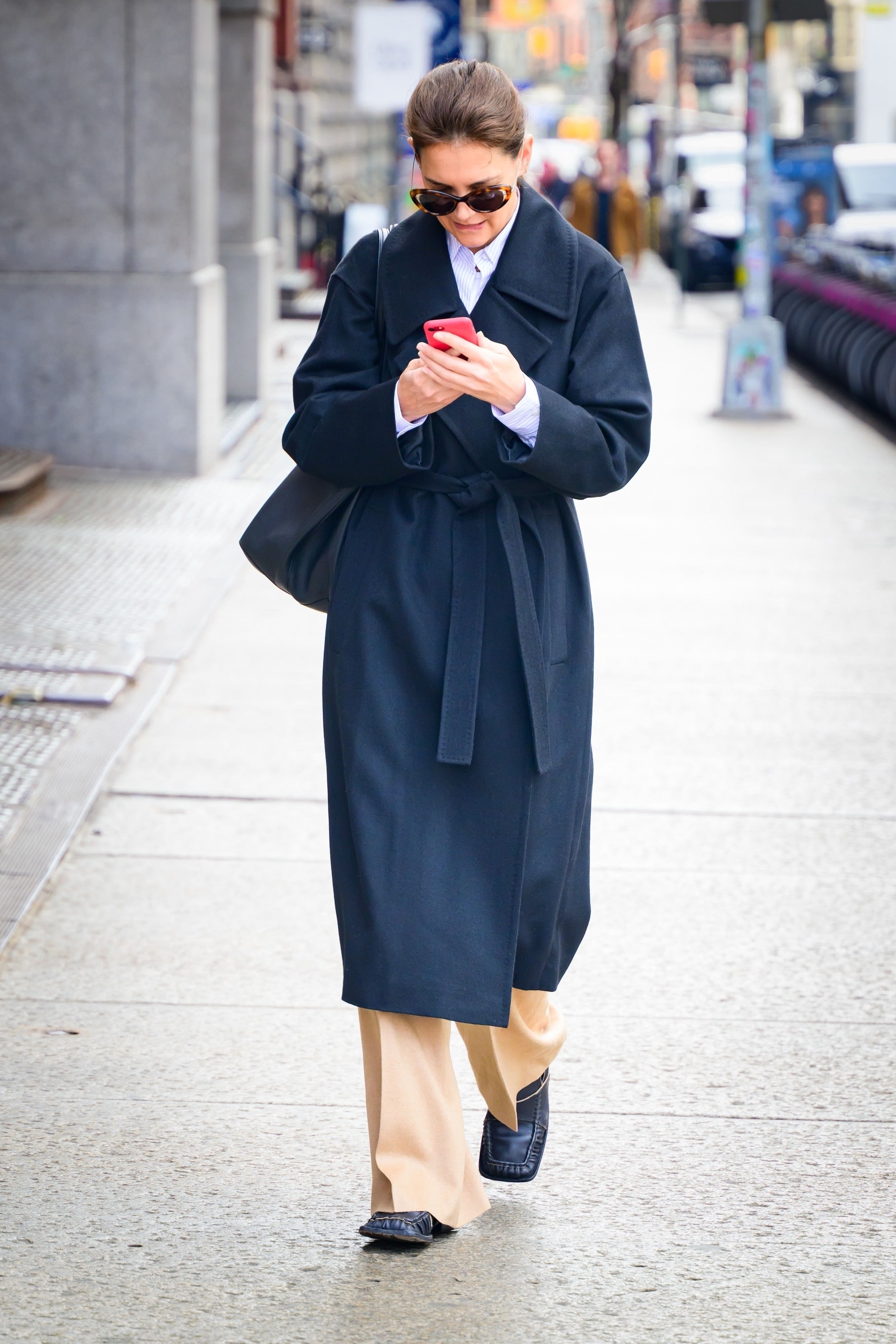 Katie Holmes wearing a navy trench coat and tan trousers from Lafayette 148