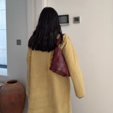 Influencer @monikh wears a butter yellow boat with a burgundy handbag.