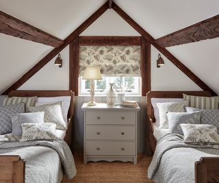 two single beds in loft bedroom with wooden beams