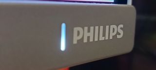 A Philips Evnia 34M2C8600 monitor on a wooden desk