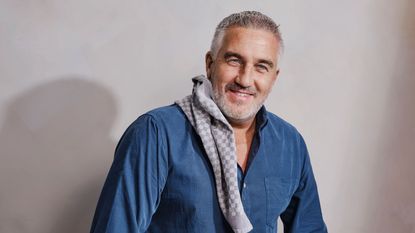 Paul Hollywood sprinkling chocolate into ramekin dishes