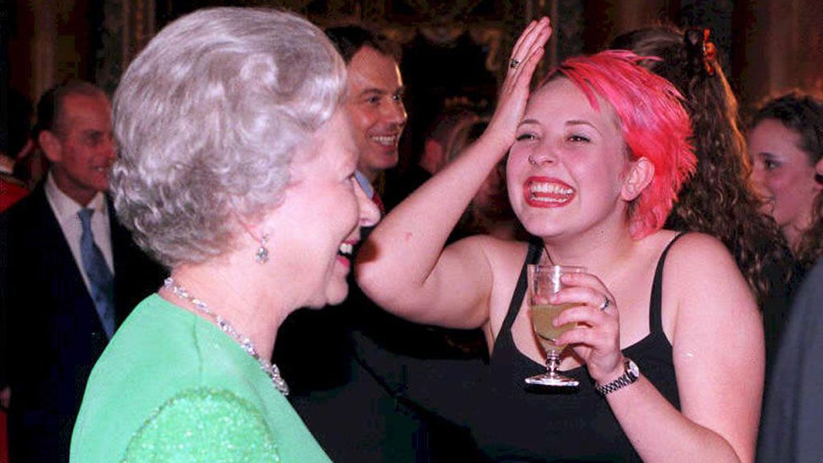 The Queen chats with Julie Thompson, a singer with the first rock band to perform at Buckingham Palace, in April 1998
