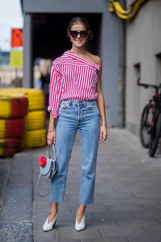 a woman wearing straight leg jeans with a bright striped top