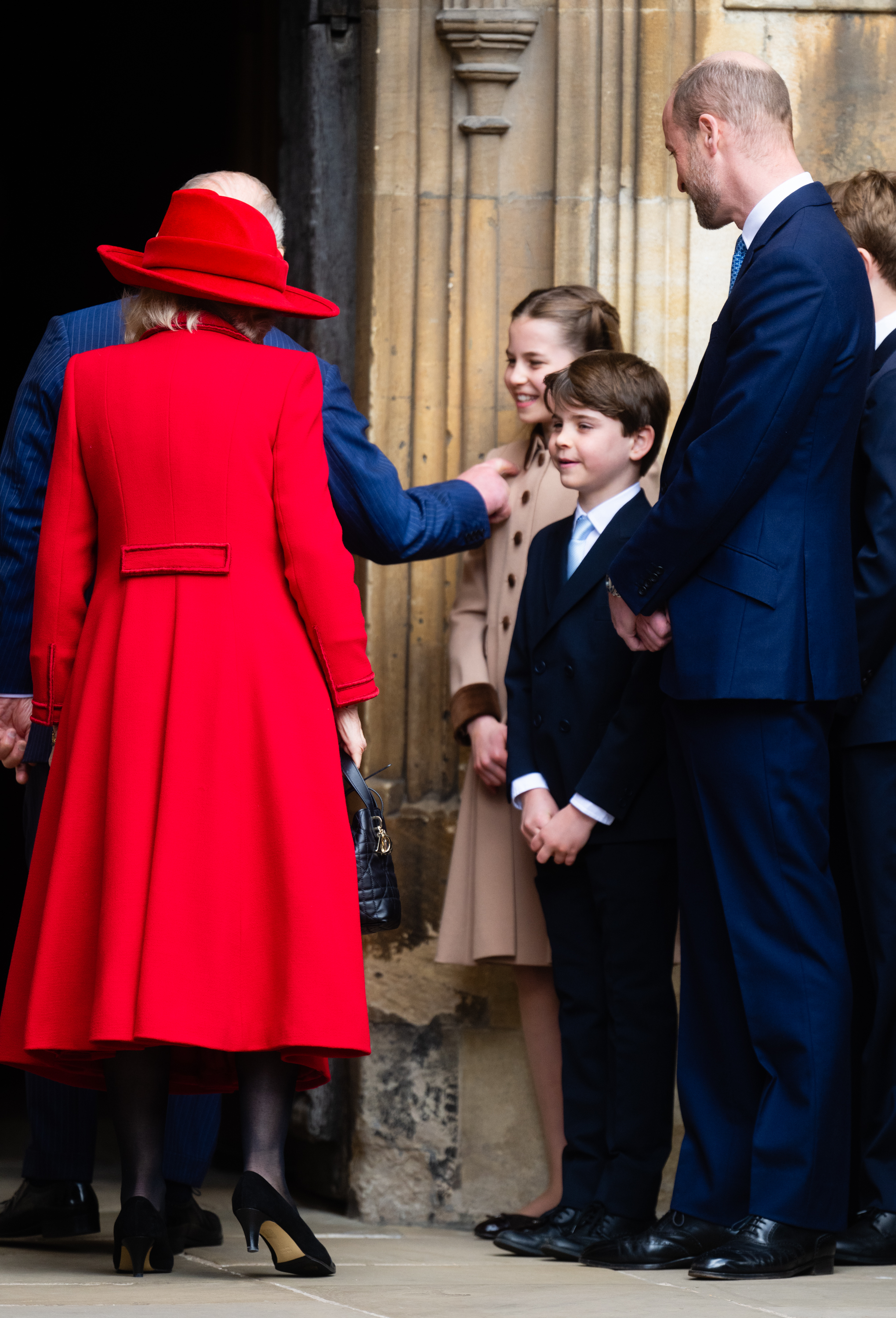 King Charles poking Princess Charlotte as Prince Louis and Prince William smile