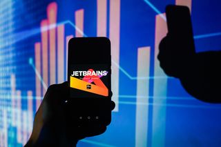JetBrains TeamCity developer logo displayed on a smartphone with multi-colored background