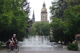 Image shows Anna cycling away from St Elizabeth's Cathedral in Košice