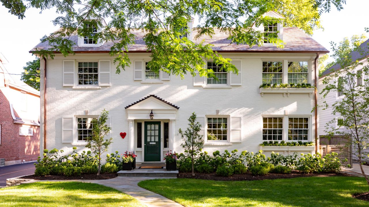 exterior of white brick Georgian house with gray door and white shutters