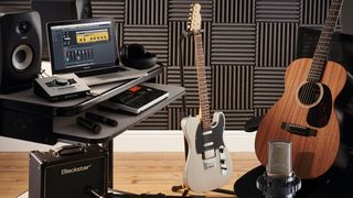 Recording studio with acoustic and electric guitars and a guitar amp in shot