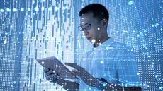 A businessman looking at a tablet in front of an abstract background of blue lines and dots