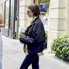 An image of Lily Collins wearing capri leggings and a white ballet flats. 
