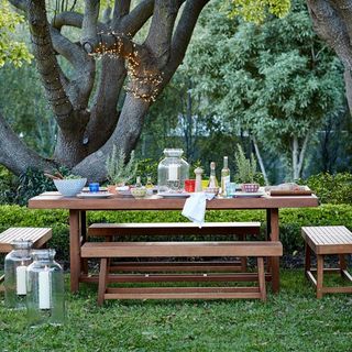 garden area with dining table and wooden bench