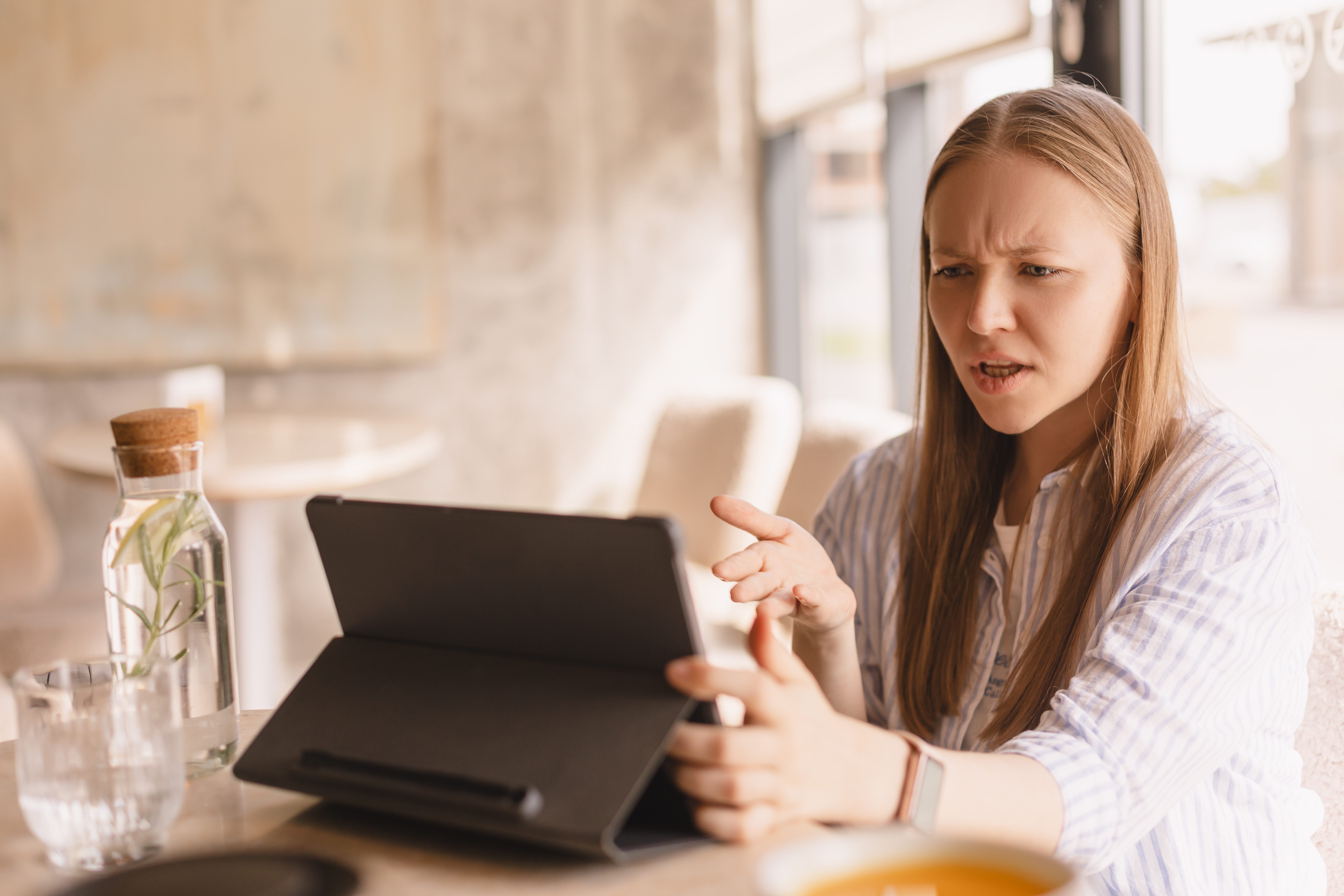 Angry person looking at a tablet.