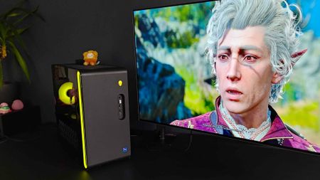 Alienware Aurora R16 gaming PC with yellow RGB lights next to Philips Evnia monitor with Astarion from Baldur's Gate 3 on screen. 