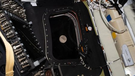 The moon is seen through the one of the Artemis II Orion capsule's windows.