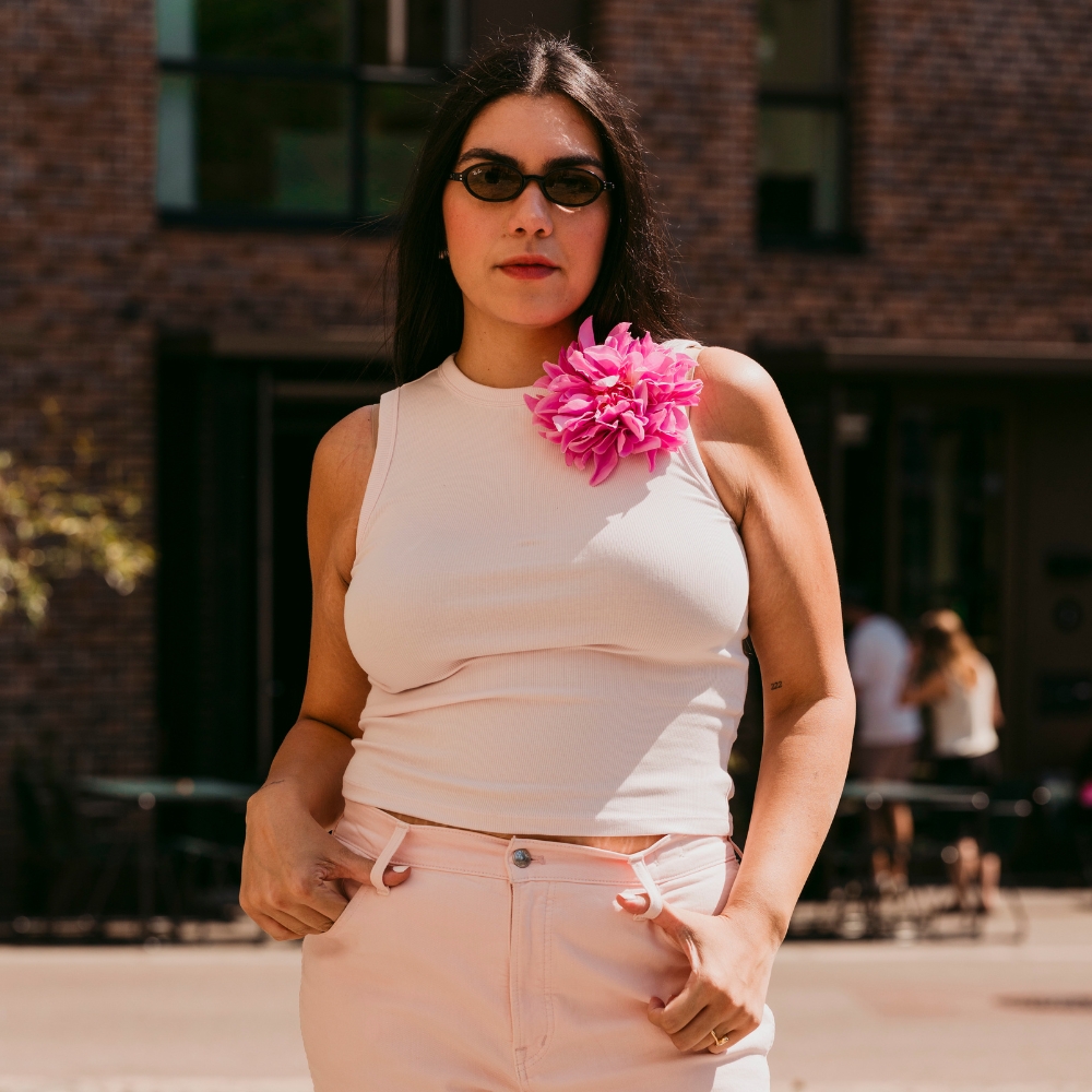 Copenhagen Fashion Week attendee wears an oversized feathery brooch with a tank top and jeans.
