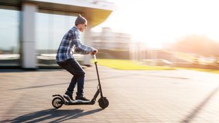 How to ride an electric scooter safely: a person riding an electric scooter while leaning back