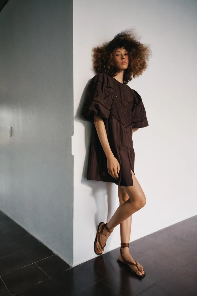 Woman wears brown minidress, brown sandals